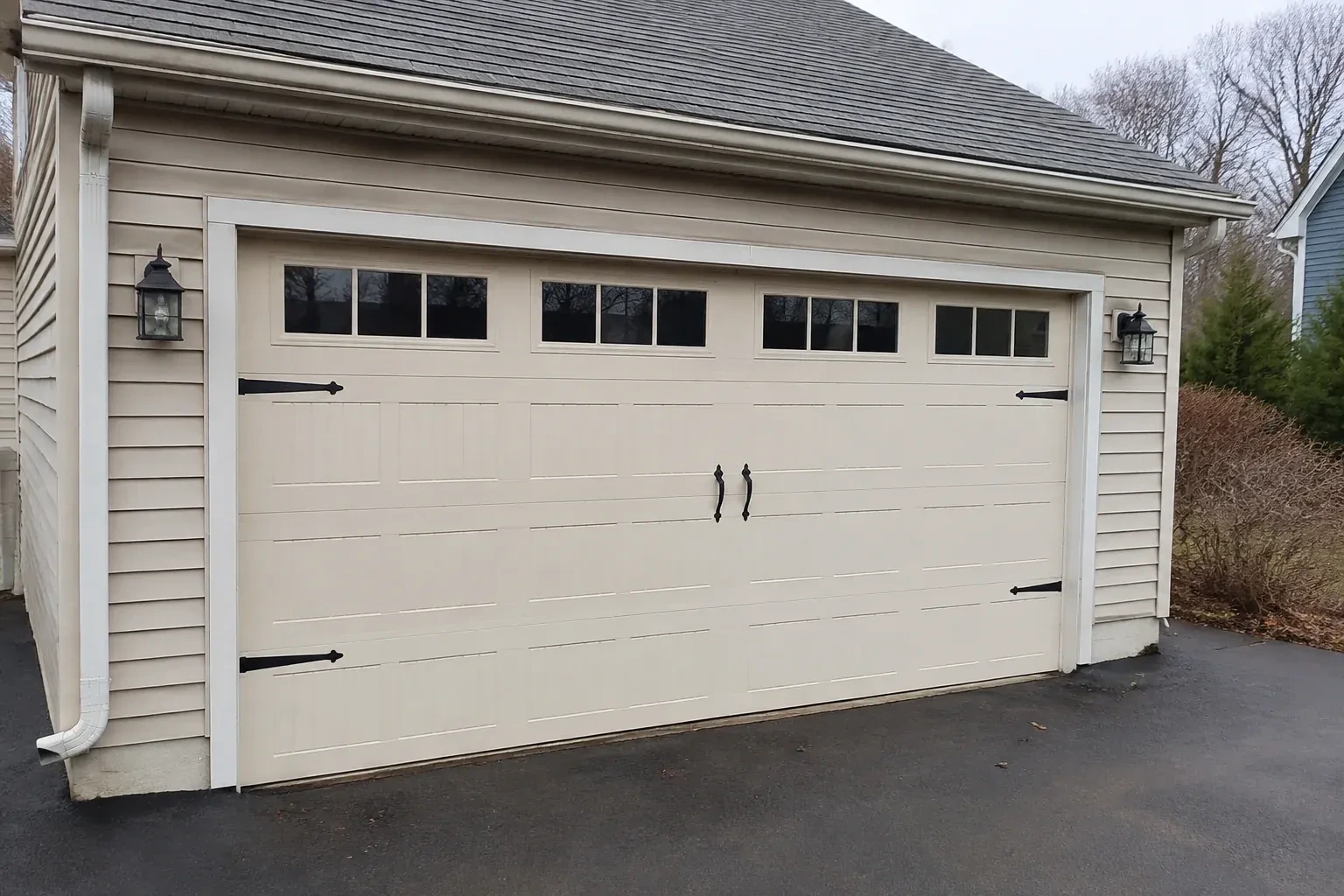 Cream carriage-house-style garage door with dark decorative hardware. — Carriage-House Garage Door Installation, Brant