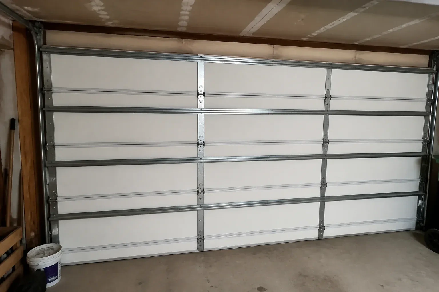 Interior of a closed sectional door with horizontal metal reinforcement struts. — Wind-Rated Garage Door Replacement, Brant